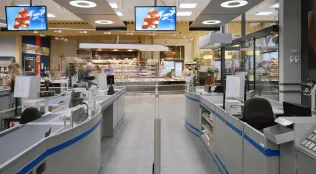 Kassenbereich eines Supermarktes mit modernen Verkaufstresen und LED-Beleuchtung