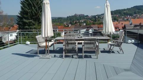 Dachterrasse mit Holz-Möbel und Blick auf die umliegende Landschaft