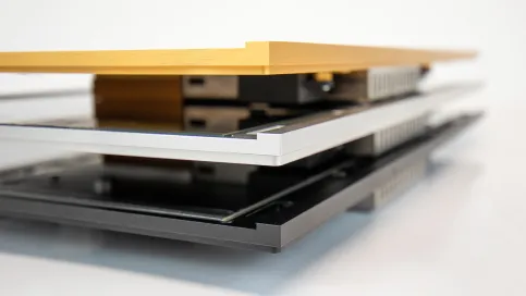 Detailansicht eines mehrschichtigen Fassadenelements mit Aluminium- und Glasoberflächen