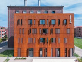 Dynamische Fassadengestaltung mit Faltschiebeläden aus Streckmetall