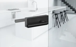 Türgriff aus mattem Schwarz an einer Glas-Schiebetür in einer modernen Küchenumgebung