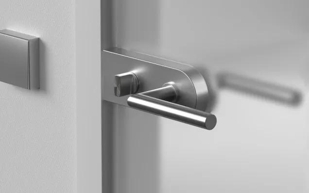 Detailansicht eines modernen Türbeschlags aus Edelstahl an einer minimalistischen Innentür