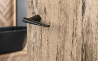 Detailaufnahme einer Holzinnentür mit modernem Türgriff und natürlicher Holzmaserung